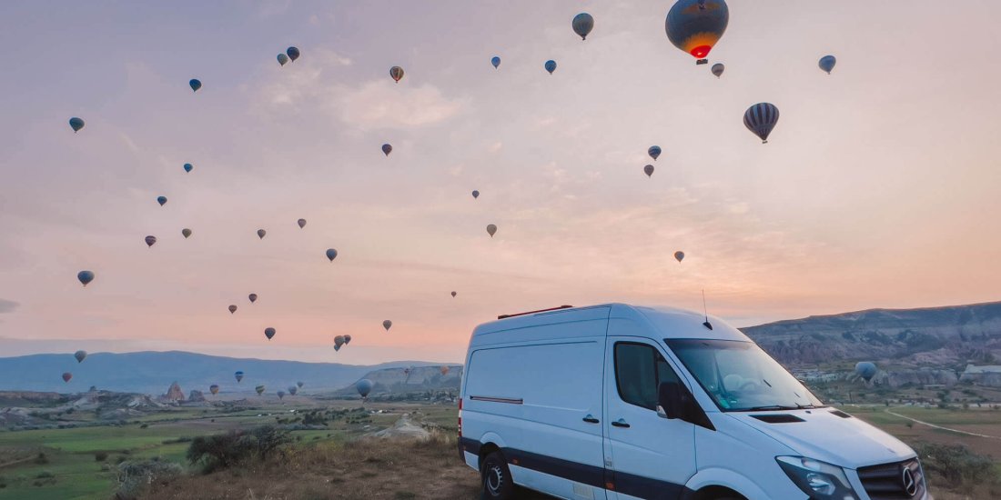 Notre fourgon devant les montgolfières en Cappadoce pendant notre road-trip en Turquie